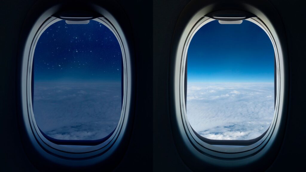 Two airplane windows side by side, left one is night outside with stars showing and right one is day time